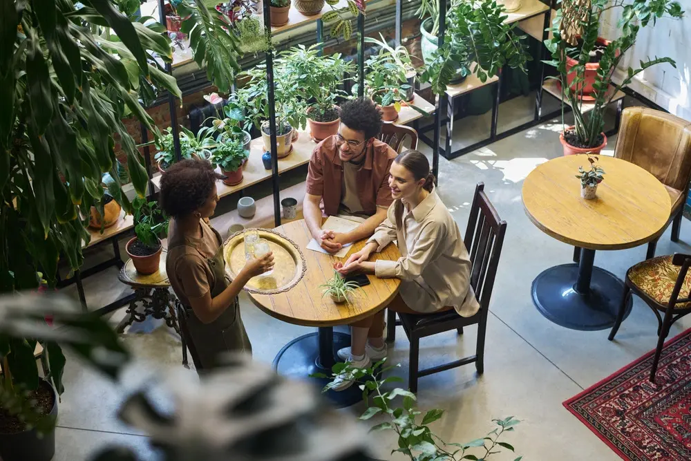 above-angle-of-waitress-with-tray-serving-young-in-2023-11-27-05-19-16-utc