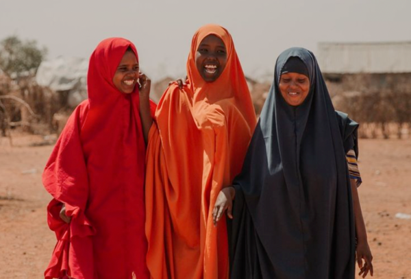 3 women in colorful outfits