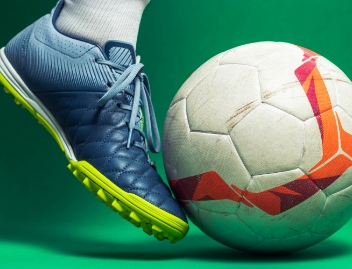 Photo d’un pied qui frappe un ballon de soccer. 