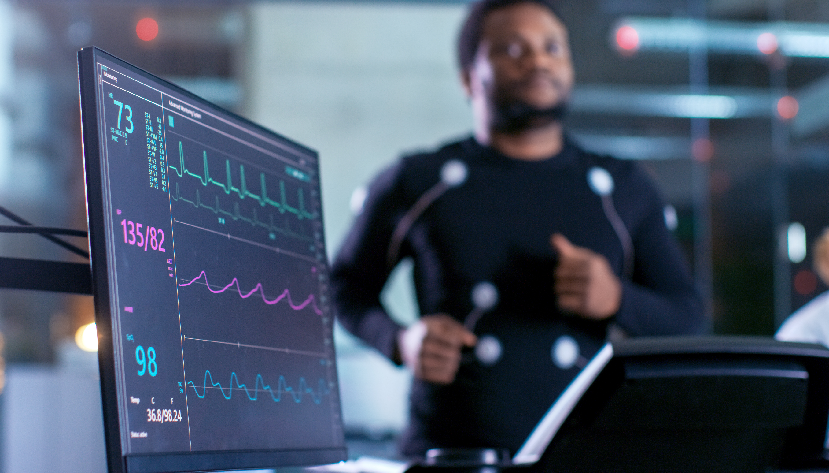 Photo d’un homme sur un tapis roulant. Un écran affiche plusieurs statistiques, telle que sa fréquence cardiaque.  