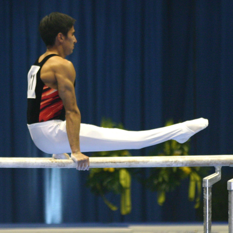 Photo d’un gymnaste se soulevant sur une barre.