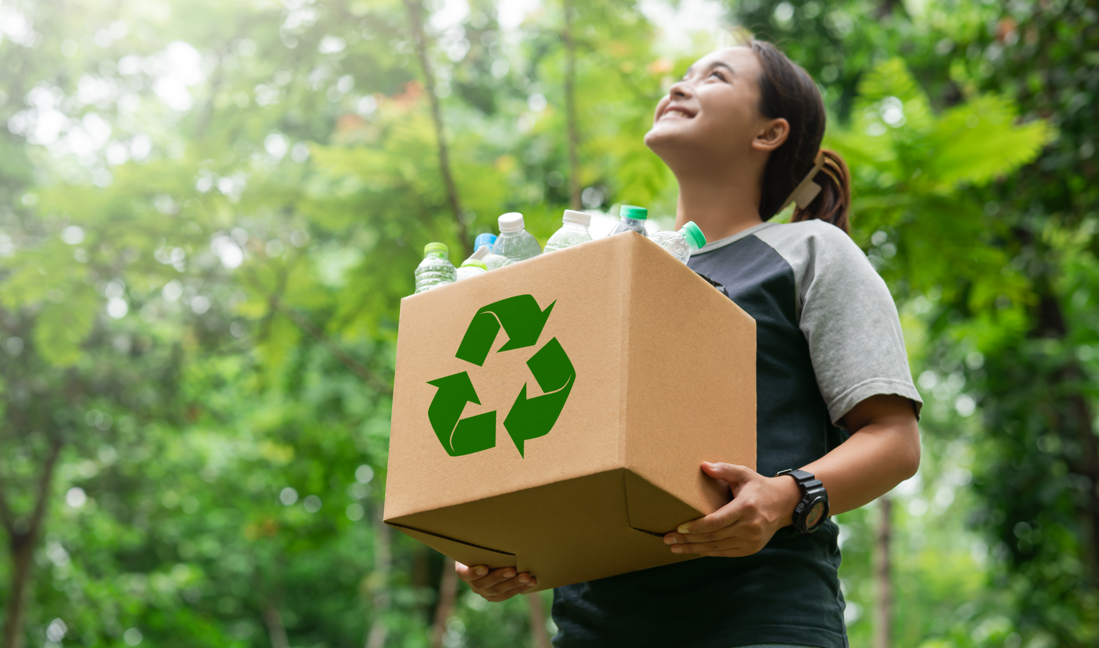 Photo d’une jeune femme qui tient une boite de recyclage.  