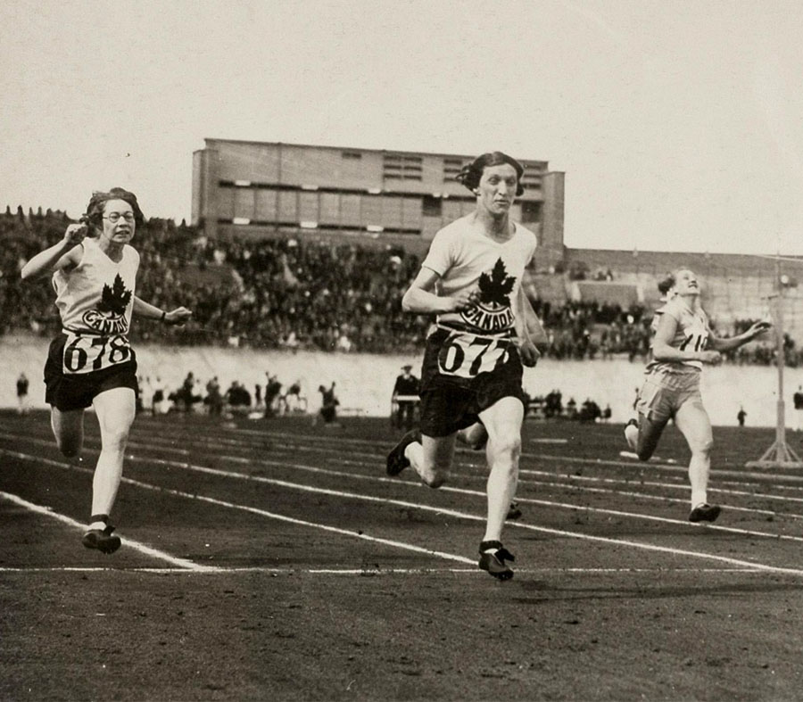 Photo en noir et blanc de Fanny Rosenfeld, importante athlète du 20ème siècle, qui court sur une piste d’athlétisme. 