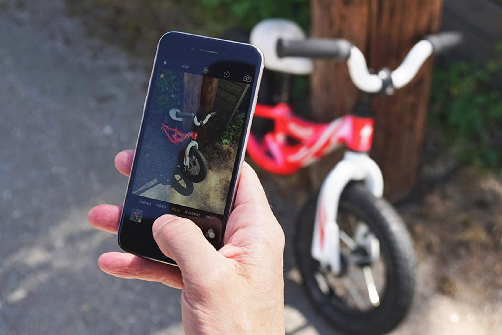 Röd barncykel sedd genom mobilkamera