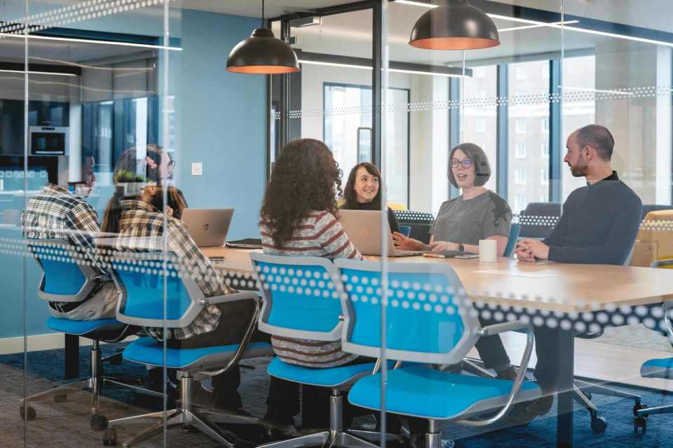 An image of a group of people discussing an activity in Platform's meeting room 