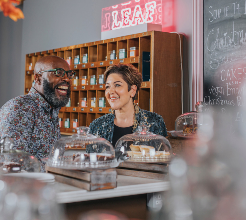 A man and a woman smiling in a cafe