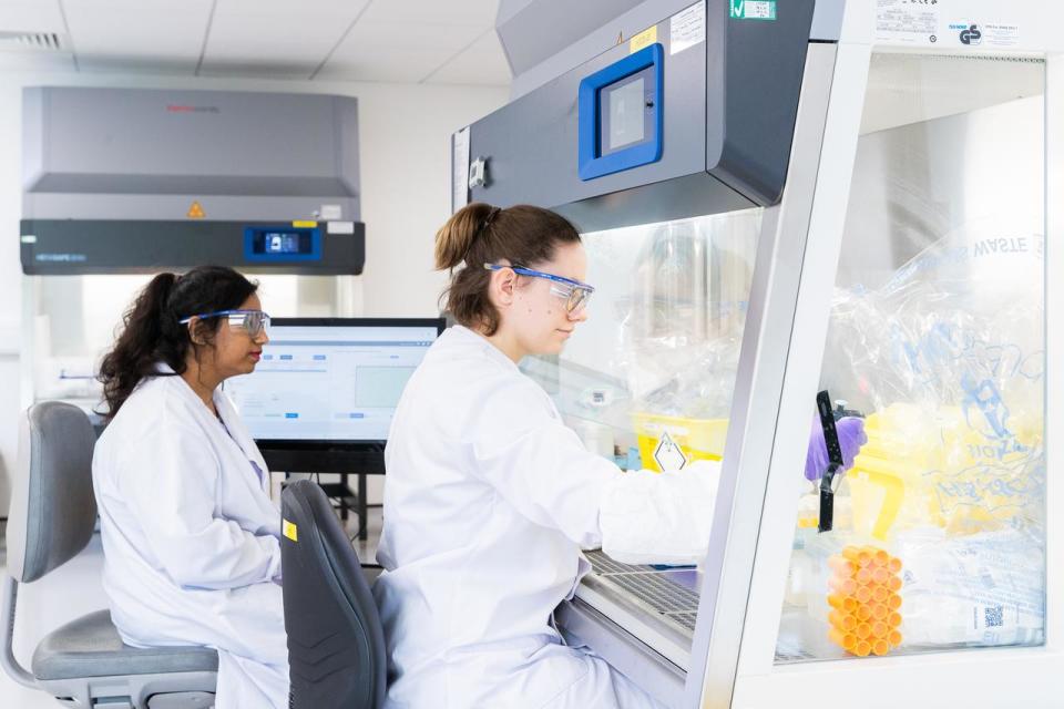 two girls working in laboratory in lab coats