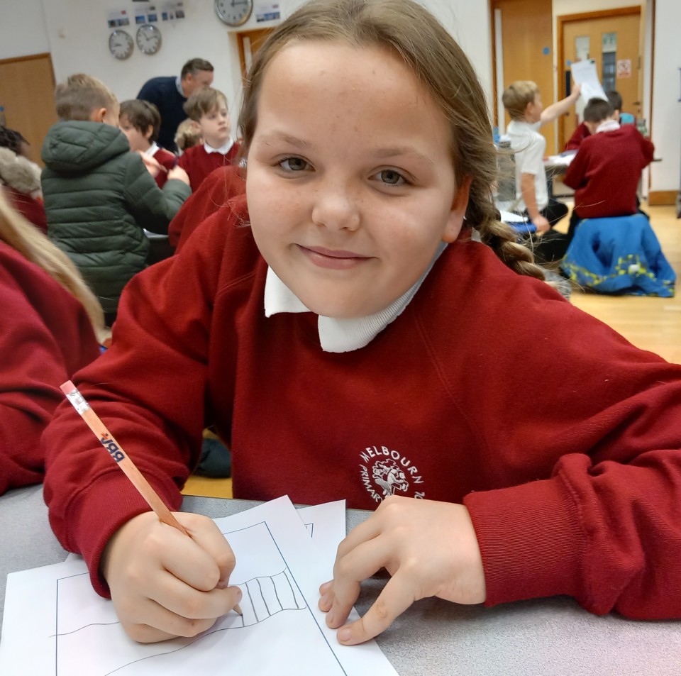 Young school girl smiling at the camera drawing