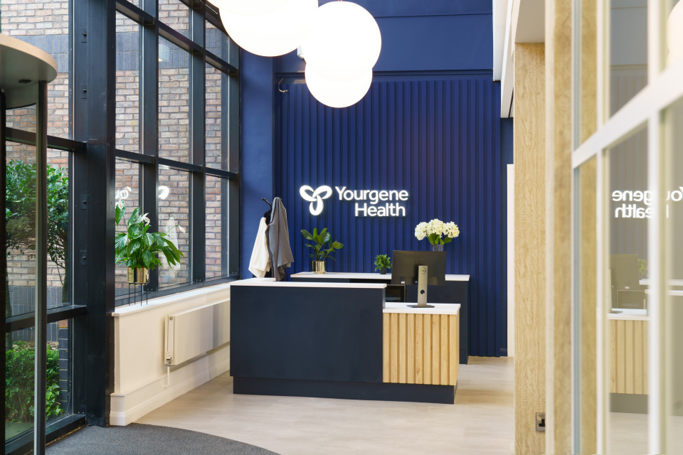 Yourgene Health's reception desk with logo behind
