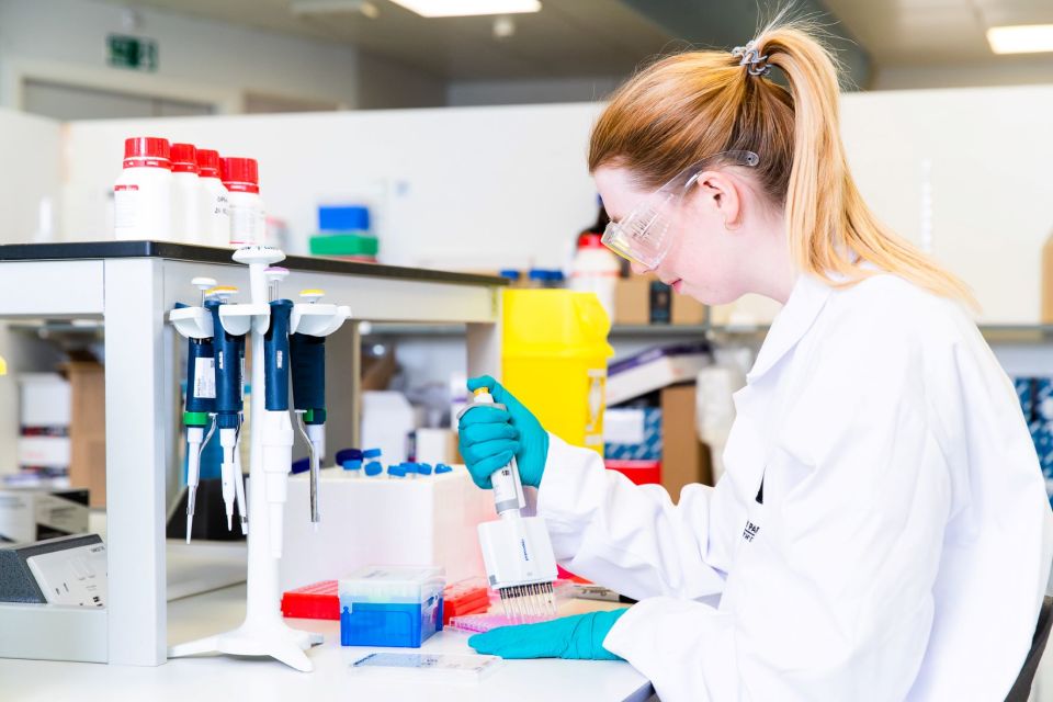 woman in lab coat looking at samples