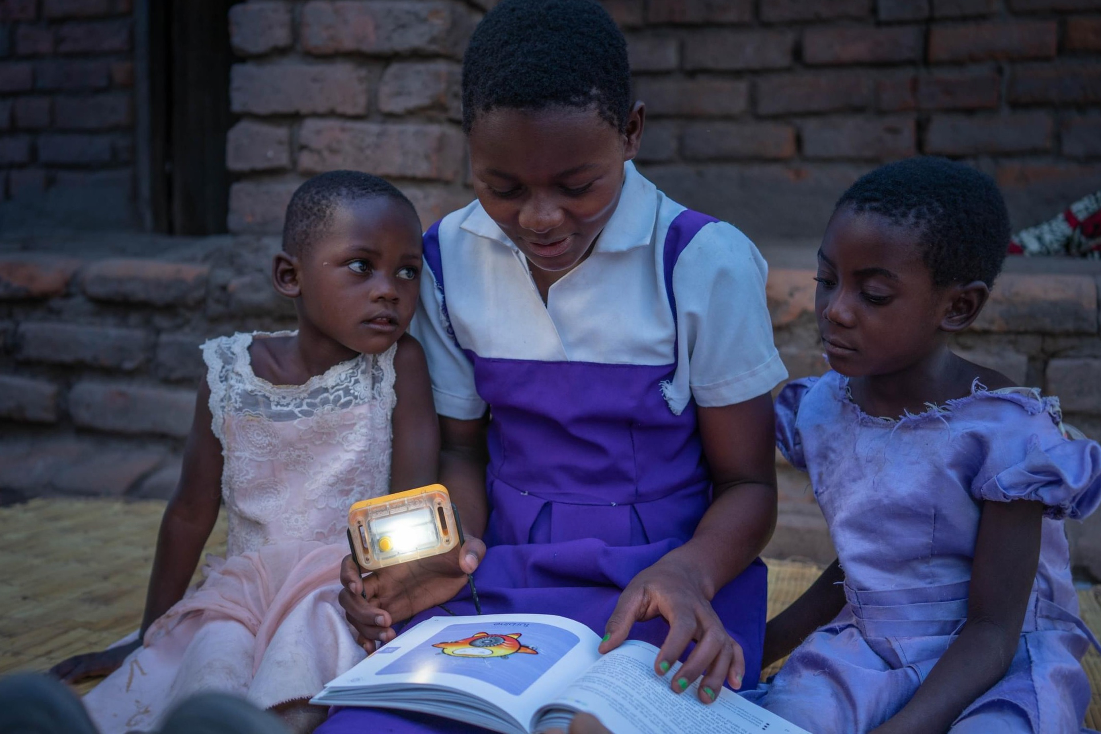 Children reading with solar lamps