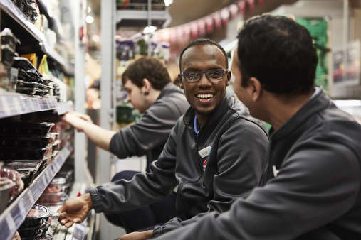 Co-op colleagues smiling while handling meat products