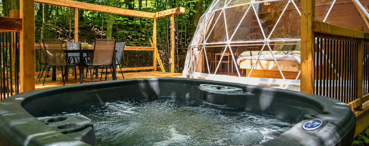 Jaccuzzi, table avec chaises sur la terrasse en arrière plan et le dôme