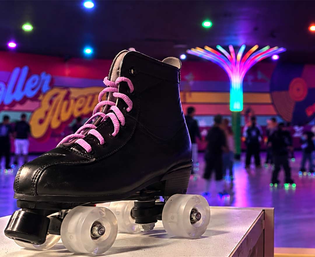 Patin à roulettes noir avec en arrière plan une piste de patin illuminée