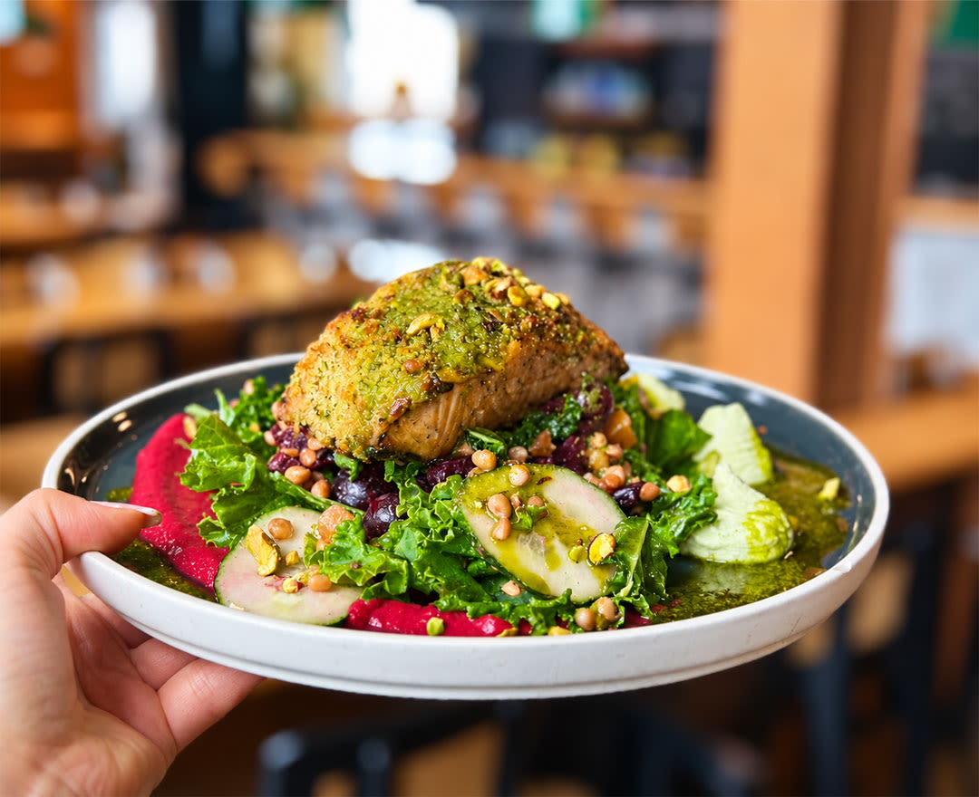 Un plat coloré composé de légumes frais et garni d’une généreuse portion est présenté dans une ambiance gourmande.