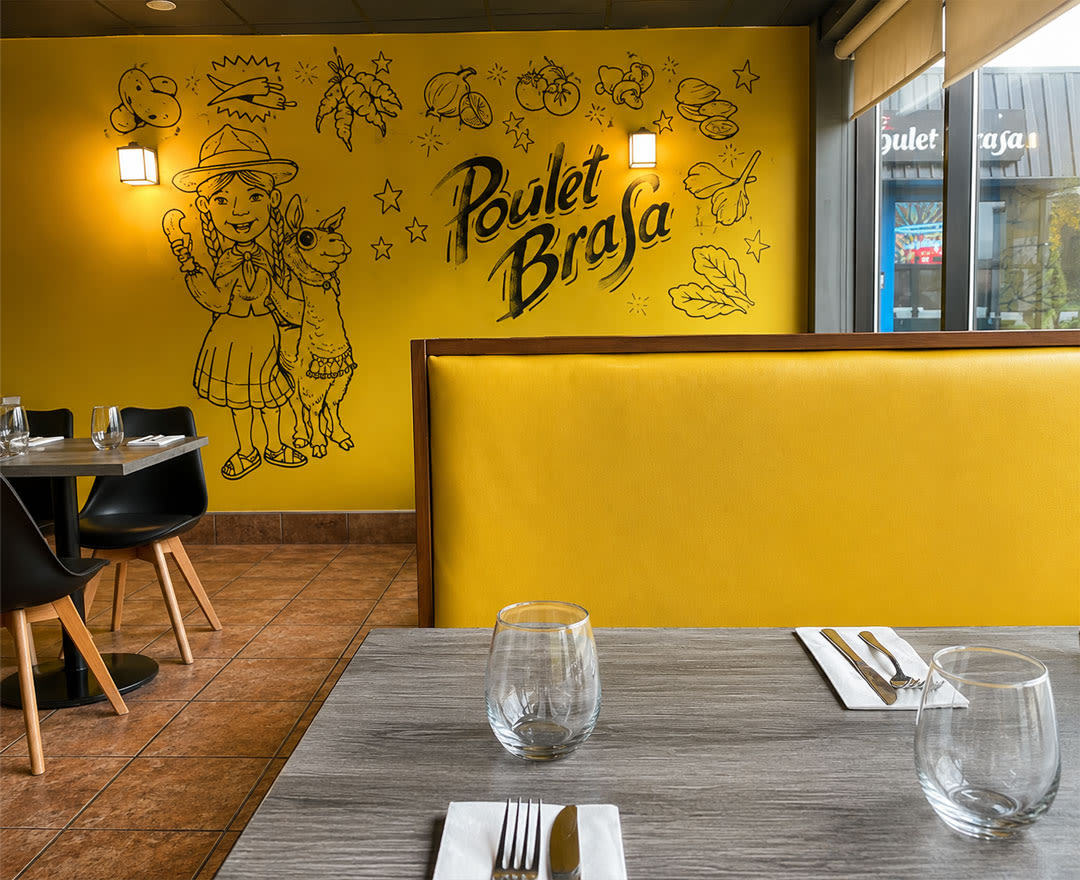 Une salle à manger lumineuse et chaleureuse aux accents jaunes, mettant en valeur l’univers coloré du restaurant Poulet Brasa.