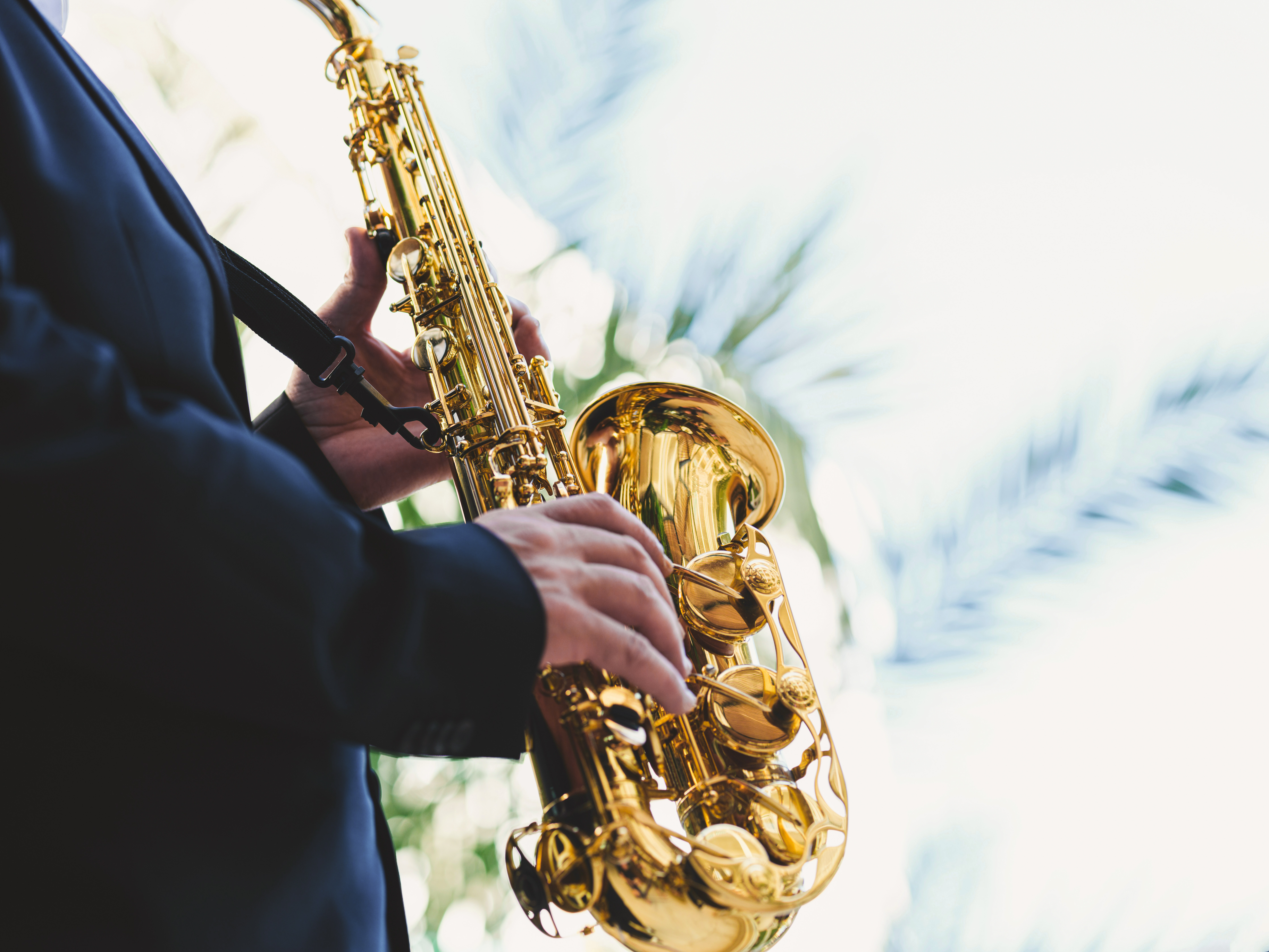 A person in a blue jacket holding a saxophone