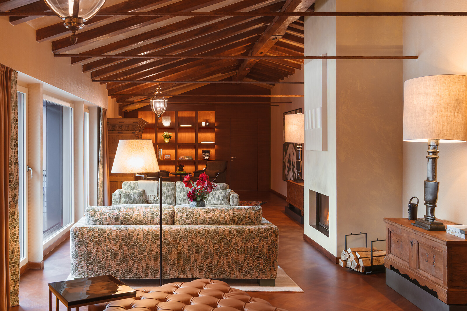 Living room in the penthouse featuring a fireplace, ambient lighting, and a table with selected flowers.