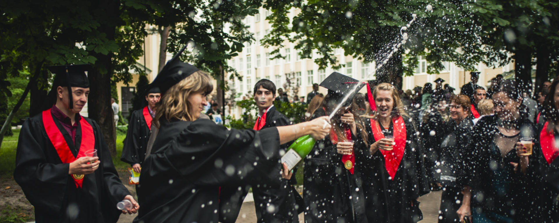 Students celebrating their graduation with a bottle of champagne. | ACI Learning