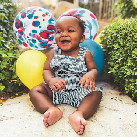 Baby sitting with baloons