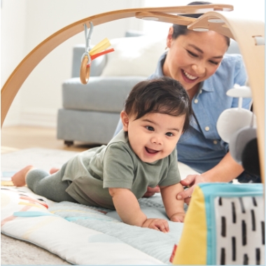 Baby plays with Discoverosity Play Gym as Mom watches