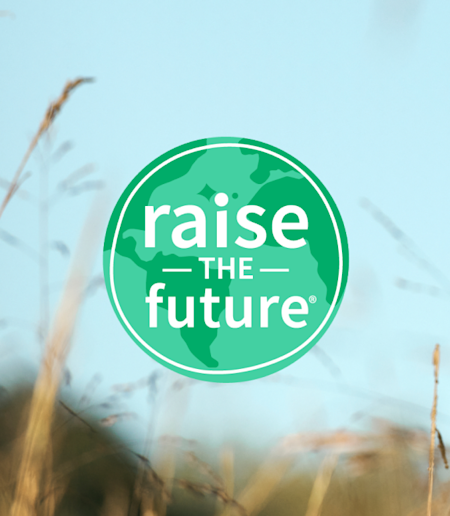 Image of sky and wheat grass with the Raise the Future globe logo overlaid on top.