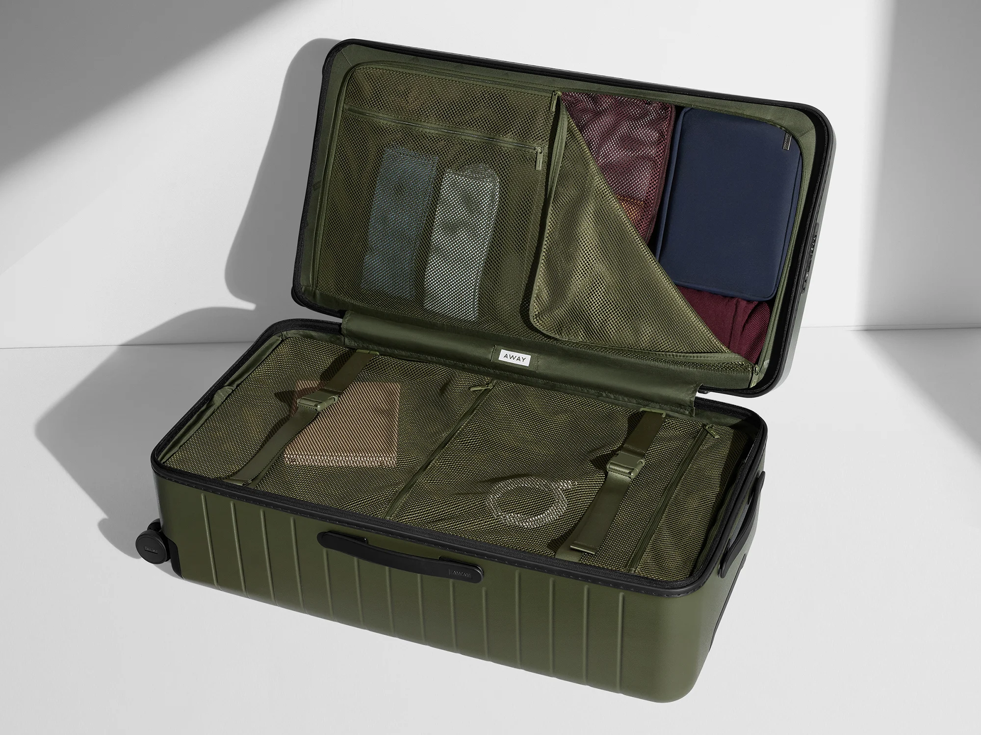 Open, packed view of the Away Trunk suitcase with travel and packing organizers