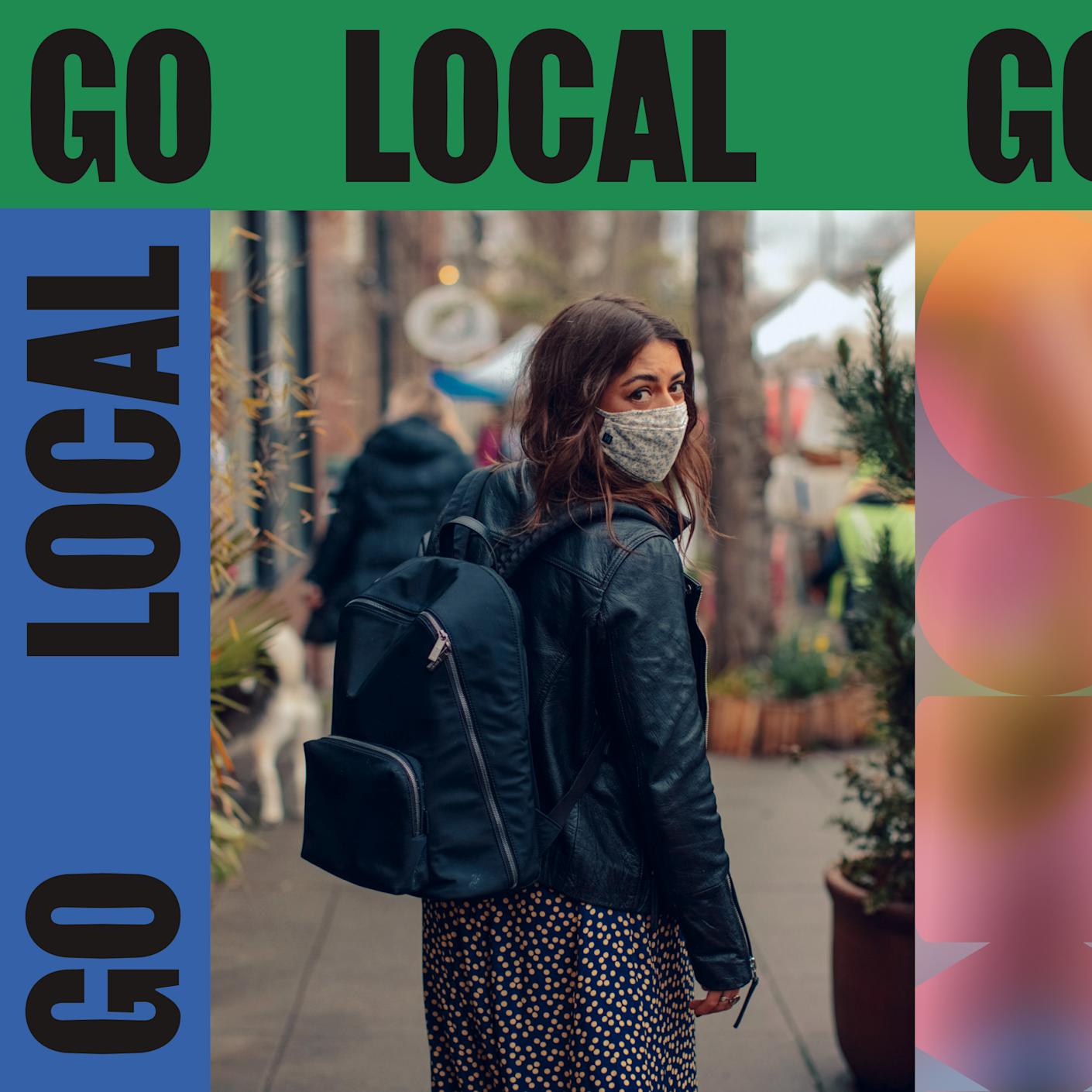 A woman with a back pack and a cloth face mask walking down a local neighborhood street with the with the label ‘Go Local’.