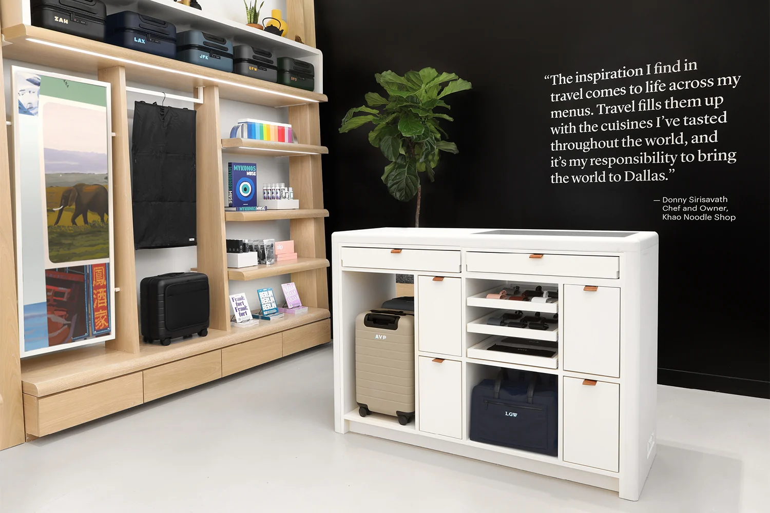  Luggage store with a travel quote against a dark wall and a display of suitcases and travel products. 