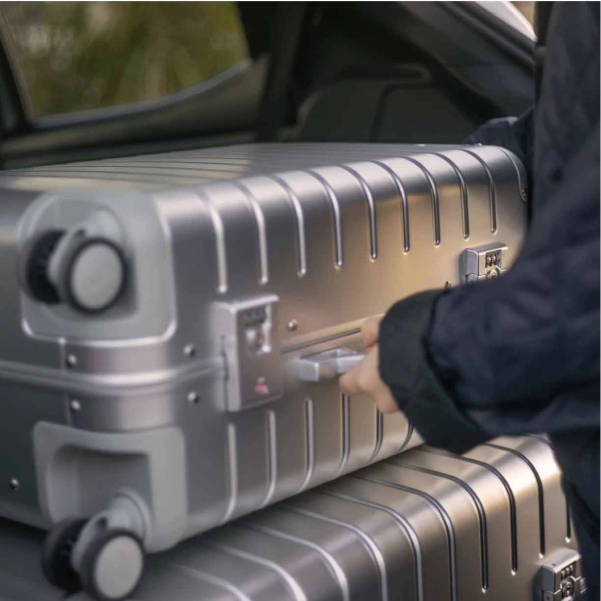 Away's Aluminum suitcases in a car, showing the dual TSA-accepted locks