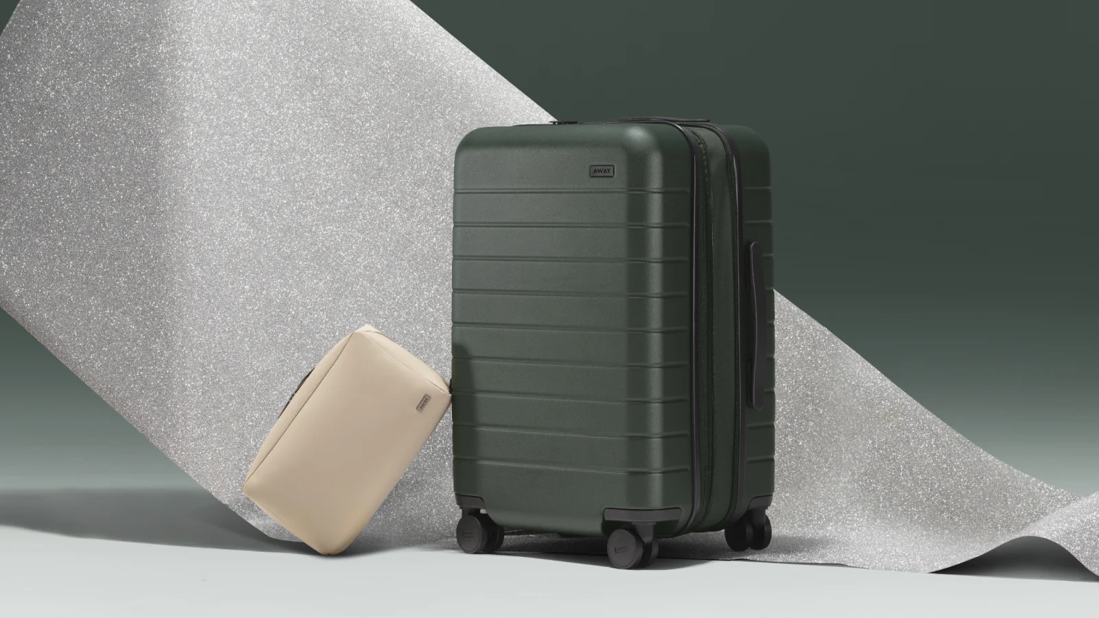 Away Bigger Carry-On Flex in Green with a Toiletry Bag in Sand. 