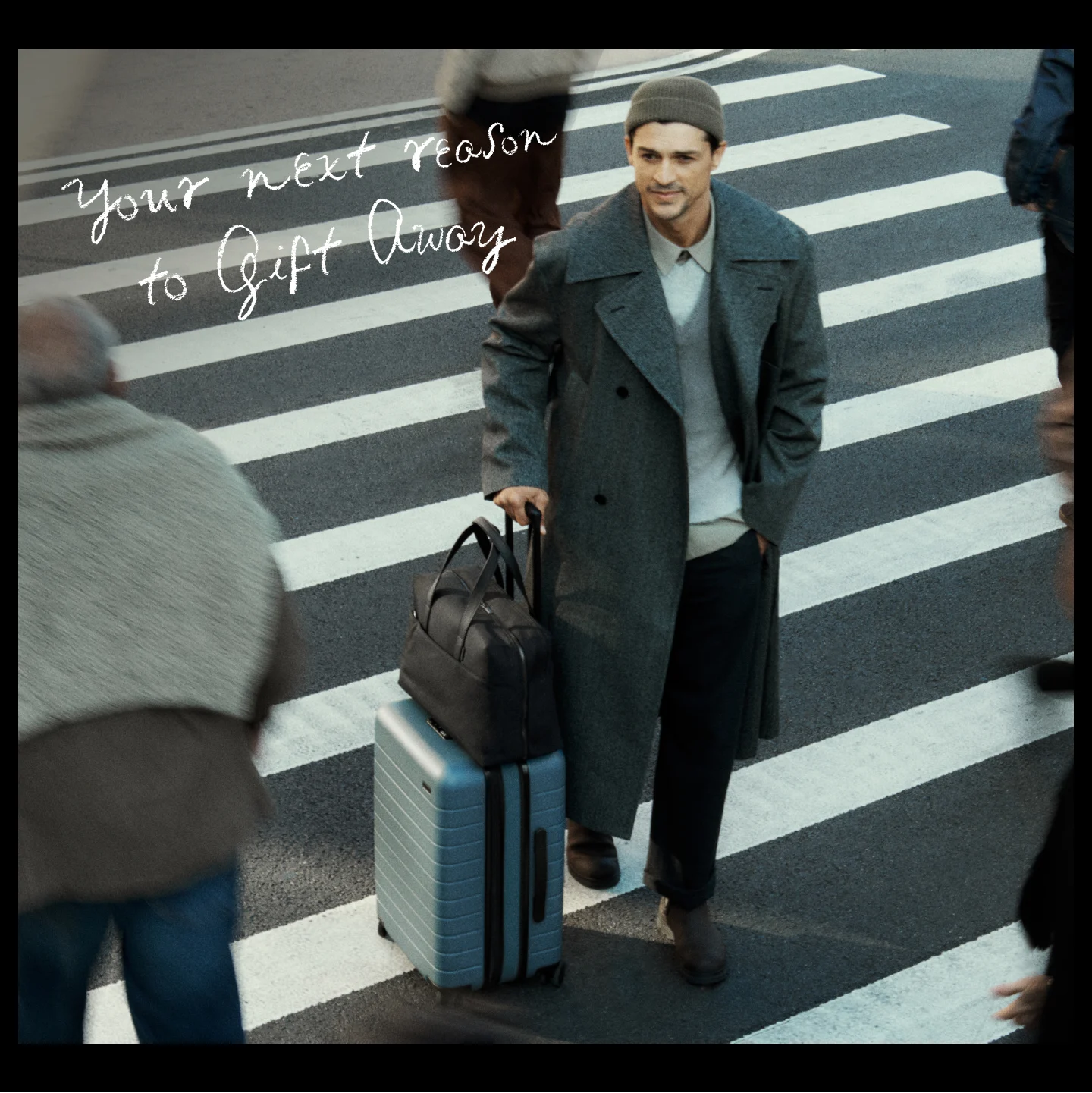 Person passing a crosswalk with an Away Carry-On luggage and Everywhere duffle bag