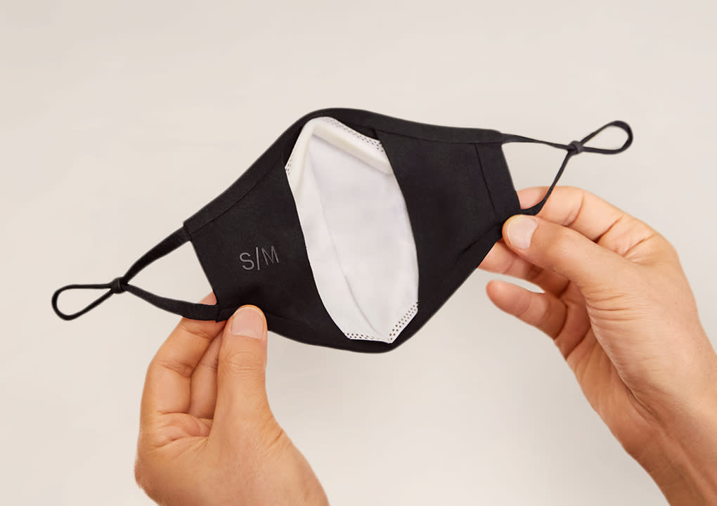 The backside of a cloth face mask for adults with the replaceable filter show