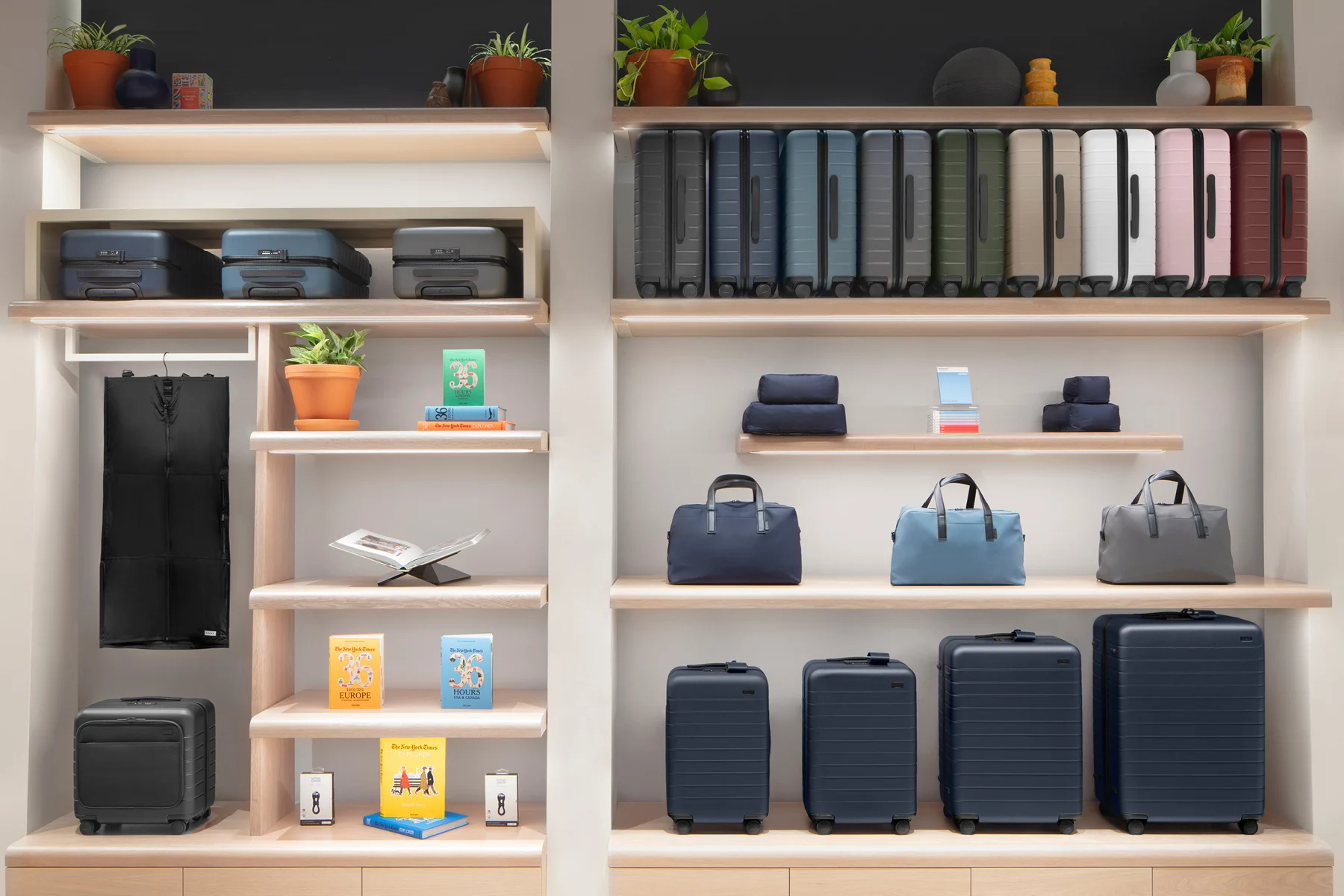 Luggage and travel products like suitcases, duffle bags, packing organizers and magazines displayed on a shelf.