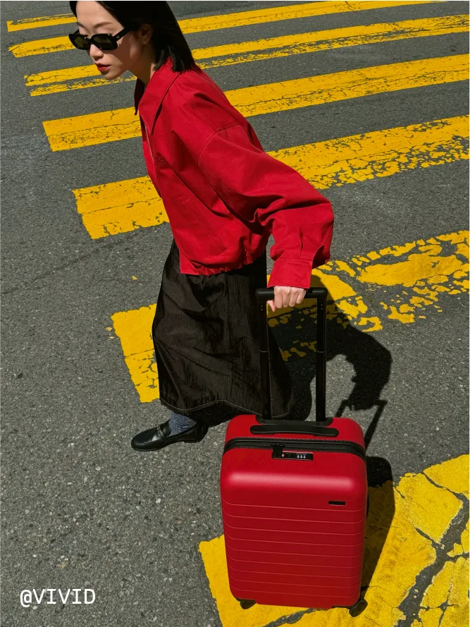 @vivid traveling with Away's Carry-On in Tango Red