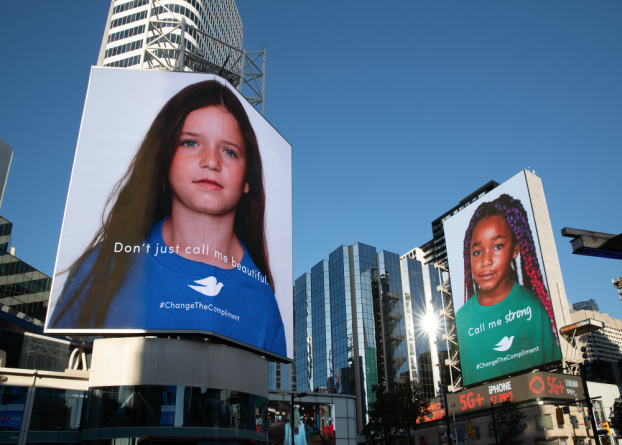 Dove's Change the Compliment campaign billboards showing headshots of two young girls on tall city building and the words "Don't just call me beautiful. Call me strong."