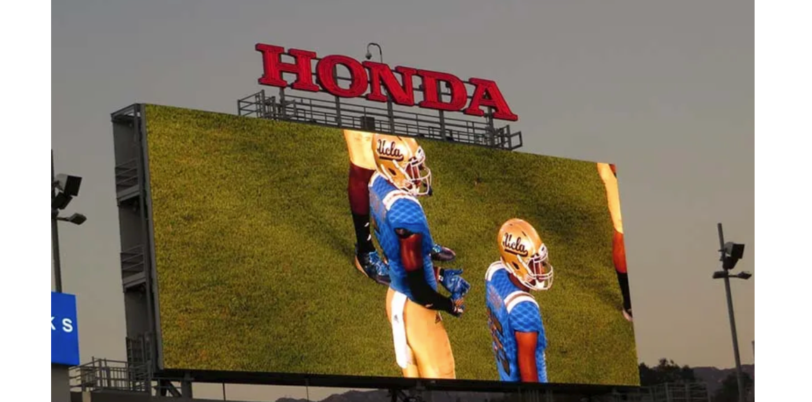 Jumbotron shows football players on the field.