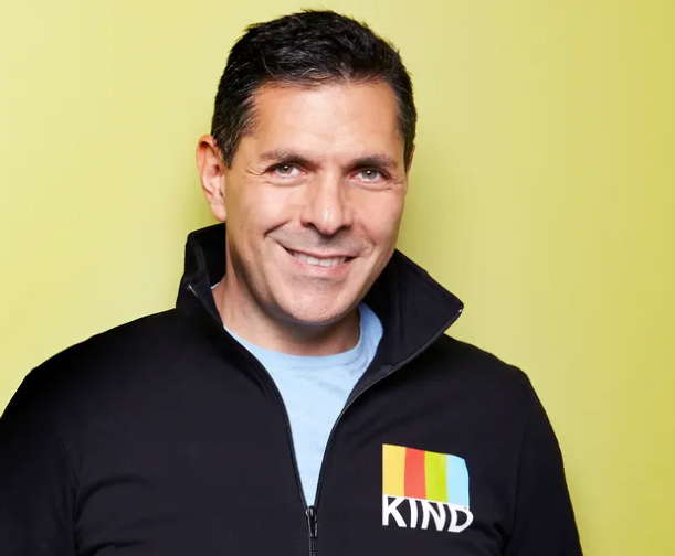 Photograph of Kind Snack founder Daniel Lubetzky in front of lime green background 