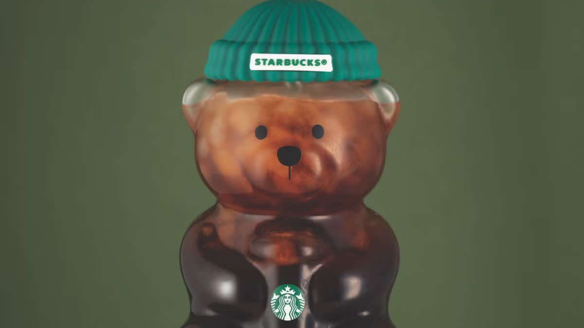 Close up photo of Starbucks' Bearista cup filled with coffee on a green background