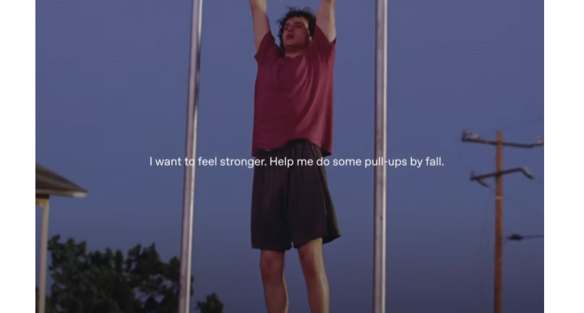 Still shot from ChatGPT's Pull Up ad showing a young man in a red t-shirt doing a pull up