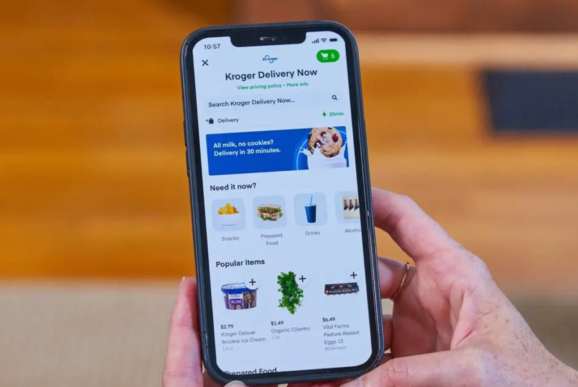 Image of someone holding a cell phone with the Kroger app opened on screen