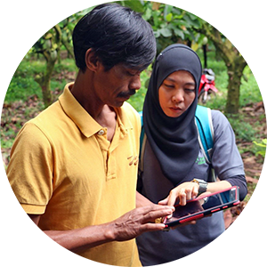 Two people outdoors engaged in conversation while glancing at a phone