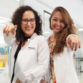 Two women pointing at the camera
