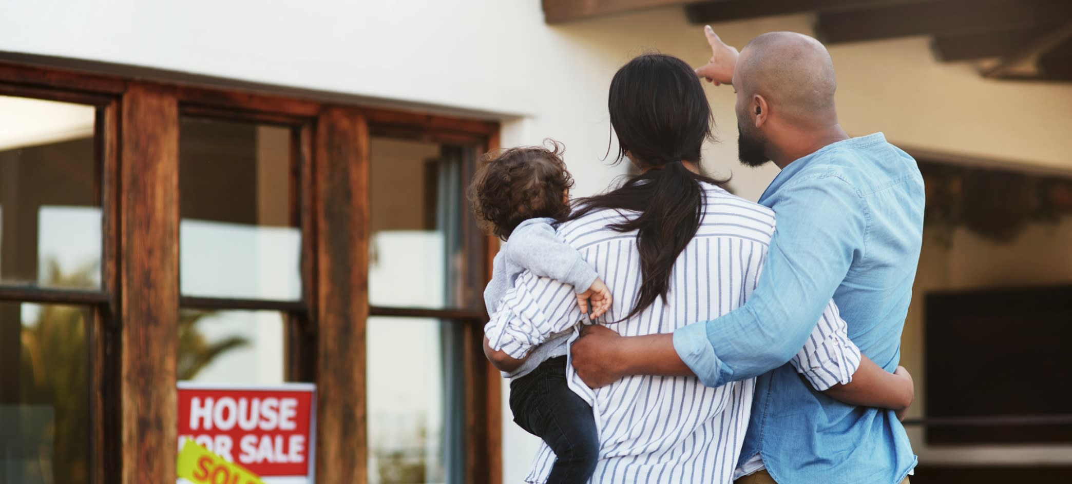 Family Pointing at Sold Home