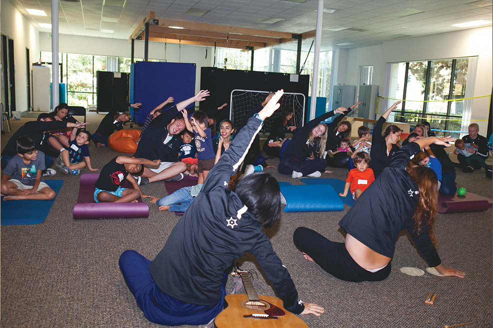 children participating in a yoga class for sensorimotor play treatment