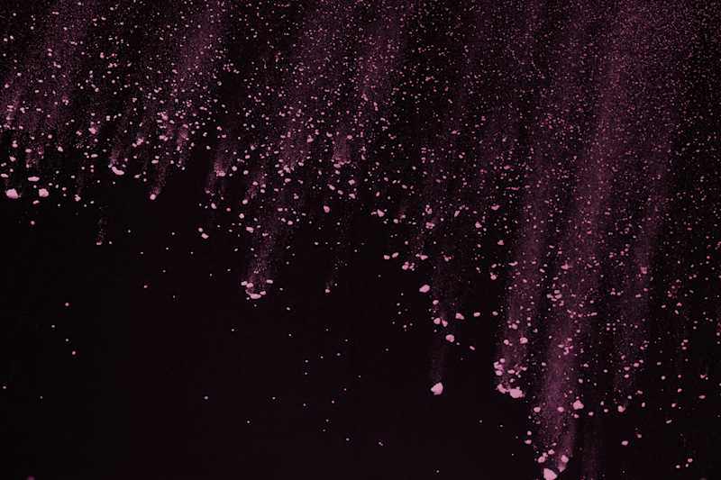 Pink particles on dark background