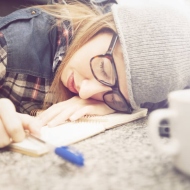 Studierende ist beim Lernen mit dem Kopf auf dem Tisch eingeschlafen