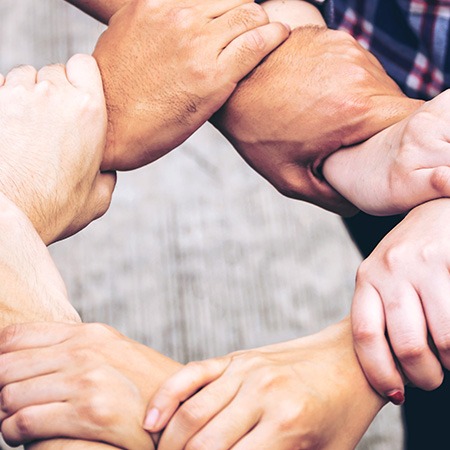 Studierende bilden eine stabile Kette aus Handgelenken