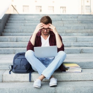 Student sitzt verzweifelt auf einer Treppe