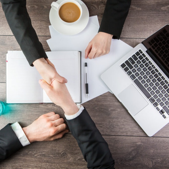 Zwei Personen schütteln sich die Hände im Rahmen eines Vorstellungsgesprächs